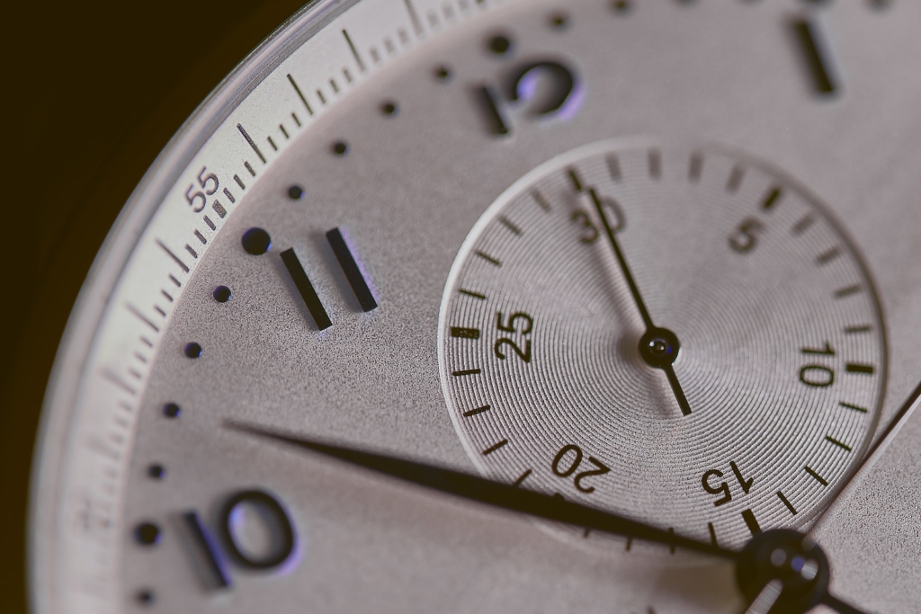 a close up of a silver watch face, working hours